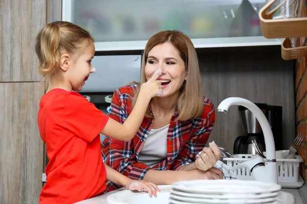 Niña y madre lavar los platos —  Fotos de Stock