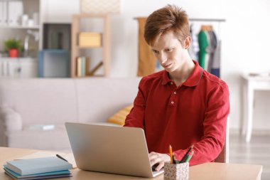 Evde ders yaparken laptop ile çalışan genç