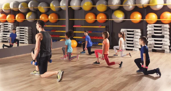 Los niños en la lección de educación física en el gimnasio escolar — Foto de Stock