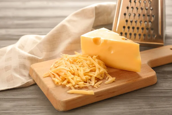 Грати і сир на дерев'яній дошці — стокове фото
