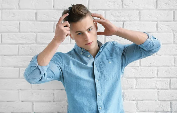 Bello giovane uomo pettinando i capelli — Foto Stock