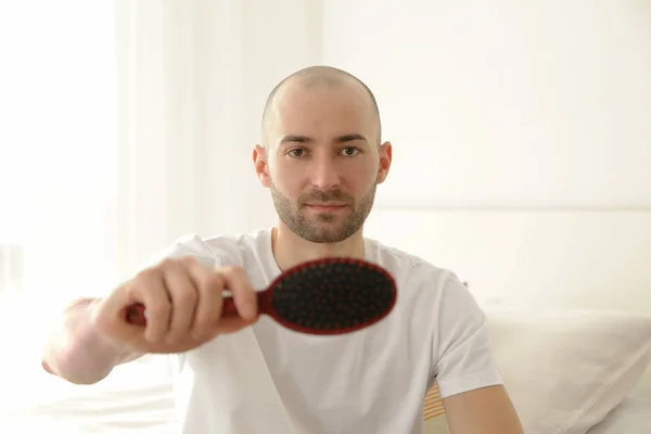 Concept de perte de cheveux. Jeune homme avec peigne à cheveux, gros plan — Photo