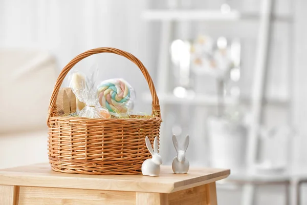 Пасхальные подарки в корзине с декоративными кроликами на деревянном стуле — стоковое фото