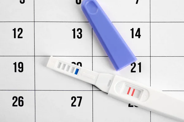 Pregnancy test on calendar — Stock Photo, Image