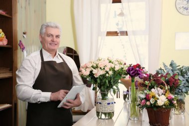 Tablet ile erkek çiçekçi 