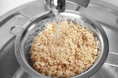 Ham kahverengi pirinç mutfak lavabo üzerinde kevgir içinde yıkama