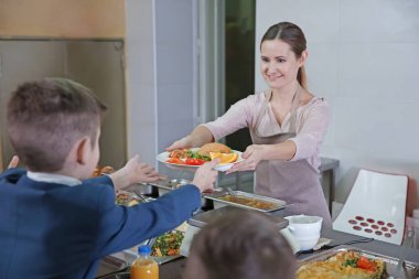 Hoş kadın okul çocuğu kafeteryasında yemek verilmesi