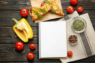 Natürmort malzemelerle pizza ve tarifi Notebook üzerinde ahşap masa, üstten görünüm