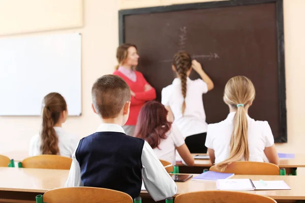 Alumnos escuchando al profesor en el aula — Foto de Stock