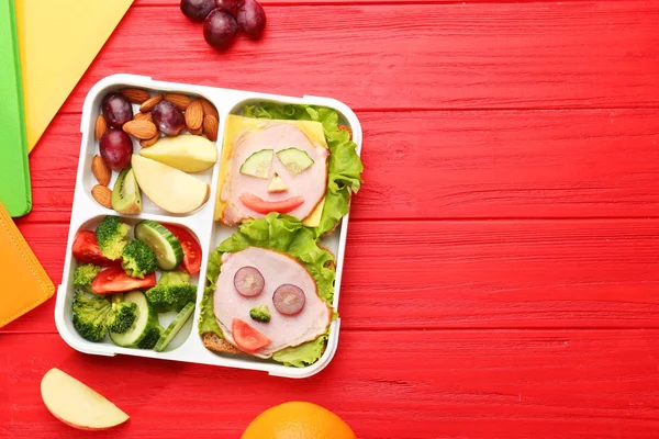 Roliga smörgåsar i lunchlåda på röd trä bakgrund — Stockfoto