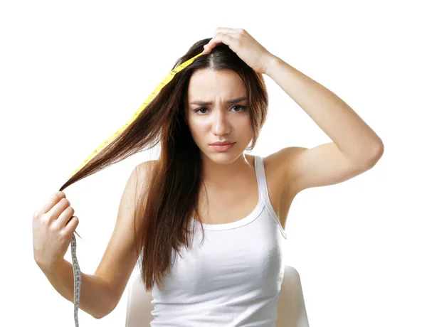 Молодая женщина измеряет длину волос — стоковое фото