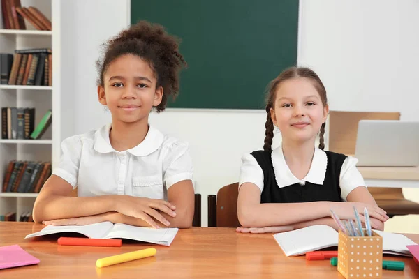 Lindas alunas elementares estudando em sala de aula — Fotografia de Stock