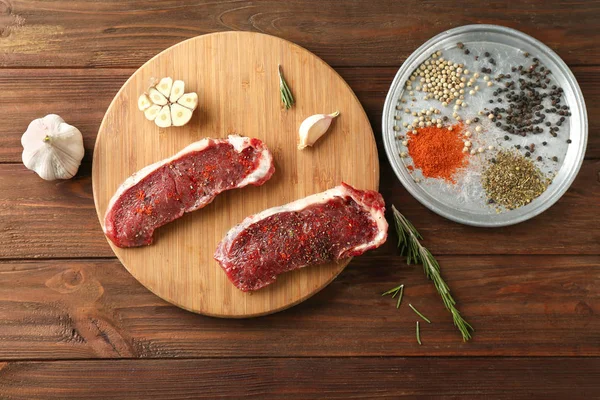 Saftige rohe Steaks und Gewürze — Stockfoto