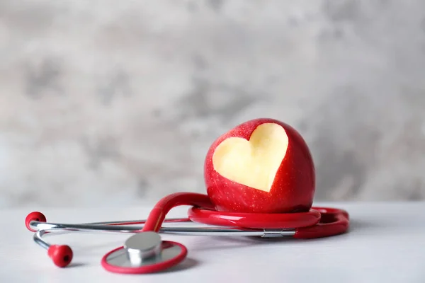 Pomme avec coupe en forme de cœur et stéthoscope — Photo