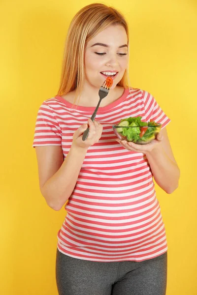 Mulher grávida segurando tigela com salada — Fotografia de Stock
