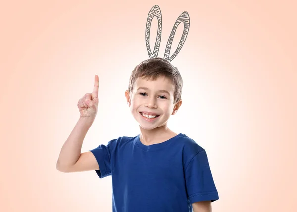 Niedlicher kleiner Junge mit gezeichneten Hasenohren auf farbigem Hintergrund — Stockfoto