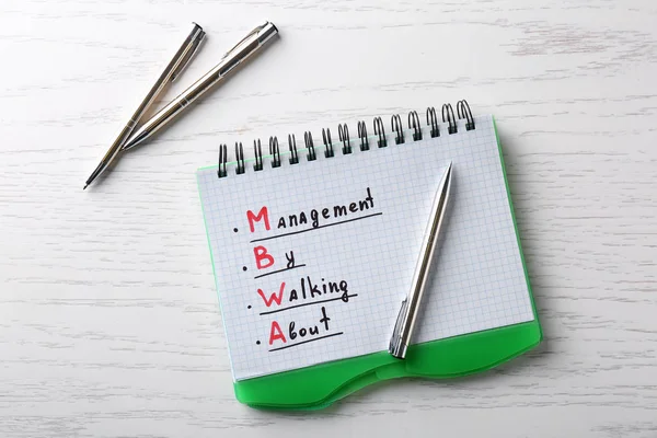 Managementkonzept. Notizblock und Stifte auf weißem Holztisch — Stockfoto