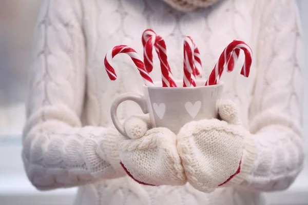 Woman holding cup with candy canes