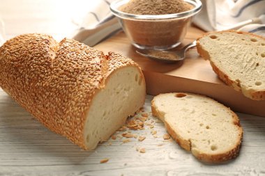 Dilimlenmiş ekmek ve cam kase tahta masada ekmek kırıntısı
