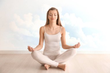 Genç kadın lotus poz gökyüzü arka plan üzerinde meditasyon. Meditasyon için uyku kavramı