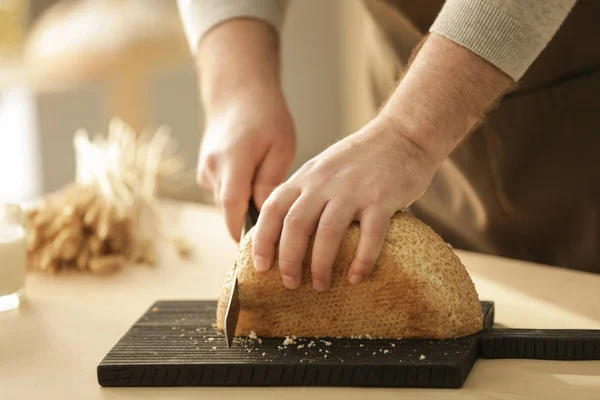 Hands of man cutting bread — Stock Photo, Image