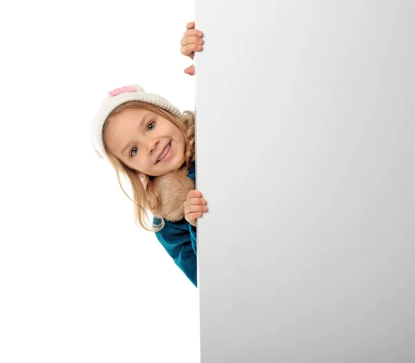 Милая маленькая девочка в теплой одежде с плакатом на белом фоне — стоковое фото
