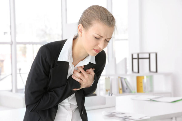 Молодая женщина страдает от боли в груди
