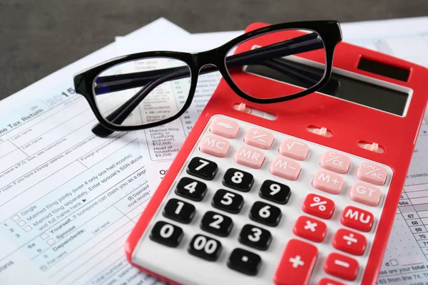 Calcolatrice con documenti e bicchieri sul tavolo. Concetto fiscale — Foto Stock