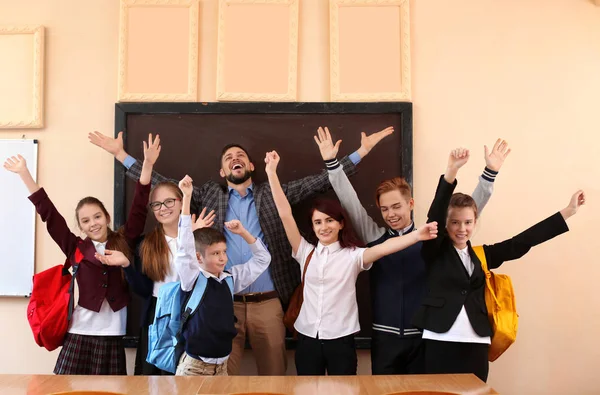 Ученики с учителем, держащимся за руки в классе — стоковое фото