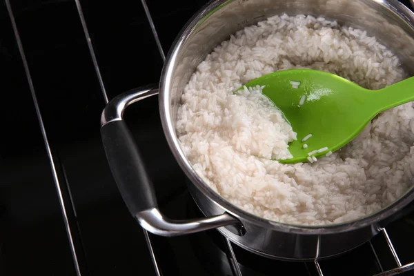 Colher com arroz na panela — Fotografia de Stock