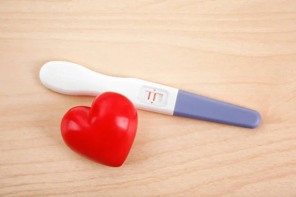 Pregnancy test and red heart