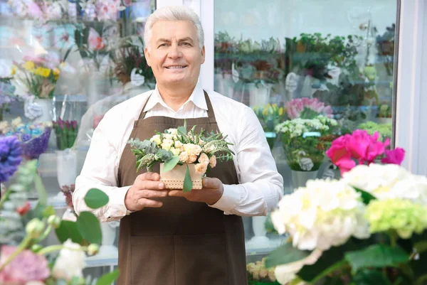 Florist holding pot with flowers — Stock Photo, Image