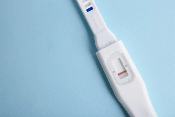 ターコイズ ブルーのテーブルの上の妊娠検査 — ストック写真
