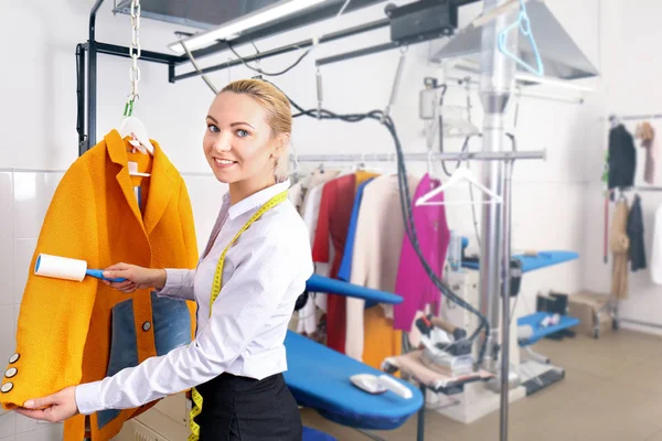 Concepto de negocio de limpieza en seco. Mujer trabajando con capa y rodillo adhesivo — Foto de Stock