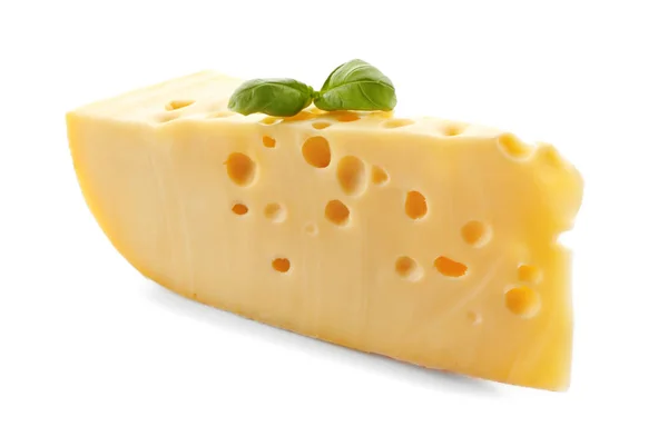 Pedaço de queijo saboroso e manjericão sobre fundo branco — Fotografia de Stock