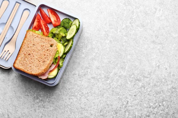 Scatola pranzo con delizioso cibo su sfondo leggero testurizzato — Foto Stock