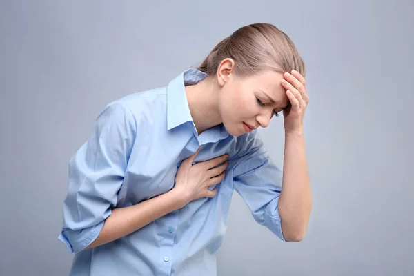 Ung kvinna lider av smärta i bröstet — Stockfoto