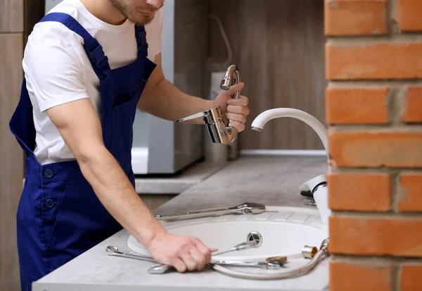 Knappe loodgieter in keuken — Stockfoto