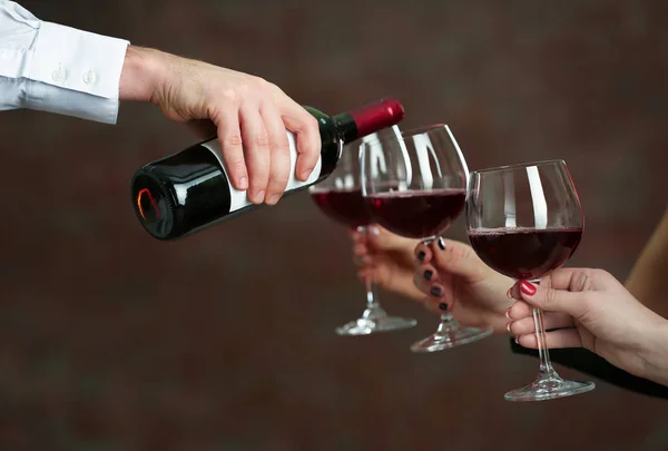 Официант, подающий вино женщинам — стоковое фото
