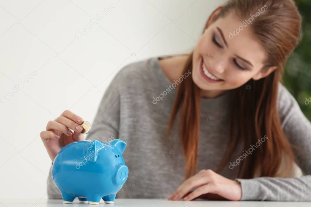 woman putting coins into piggy bank