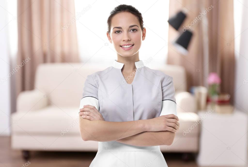 Chambermaid standing with crossed hands