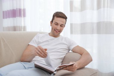 Genç adam kanepede dinleniyor.  