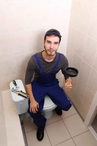 Plumber with hand plunger in bathroom — Stock Photo, Image