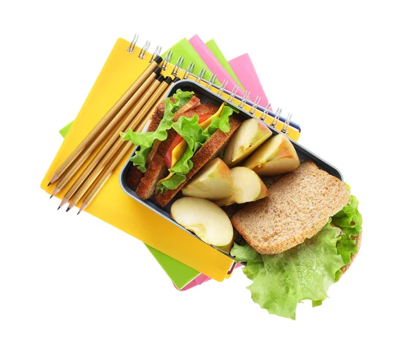 Scatola pranzo con cibo e cancelleria su sfondo bianco — Foto Stock