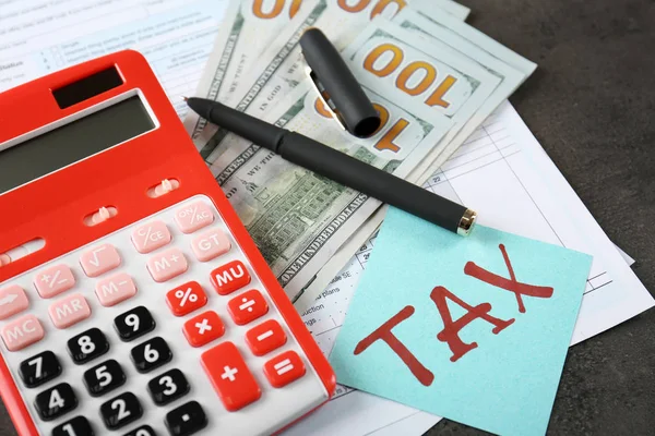 Калькулятор с документами и деньгами на столе. Налоговая — стоковое фото
