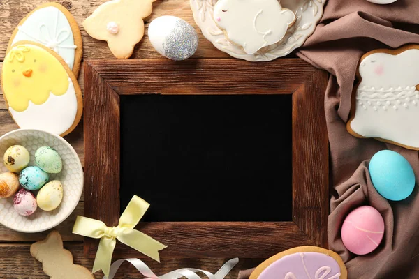 Kreidetafel mit Platz für Text und kreative Osterkekse auf Holzgrund — Stockfoto