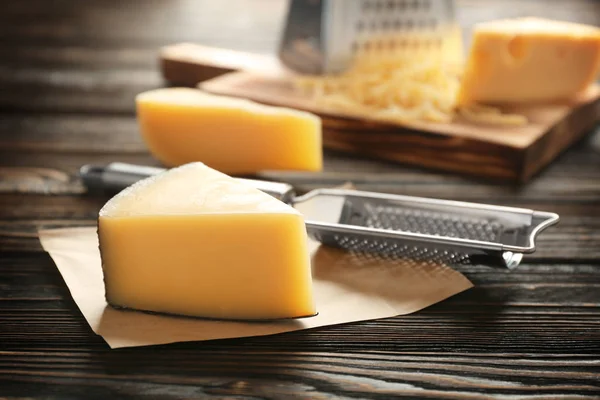 Fresh cheese and grater on wooden table — Stock Photo, Image