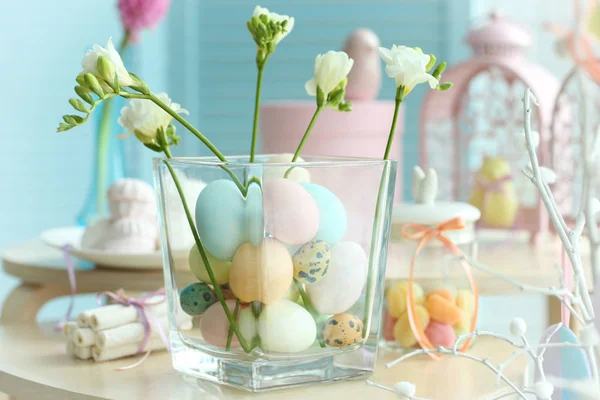 Húsvéti szimbólumok a fából készült asztal és üveg váza festett tojások — Stock Fotó