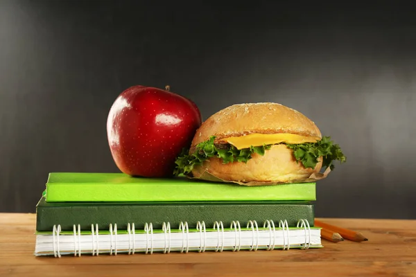 Exercise books with hamburger and apple — Stock Photo, Image