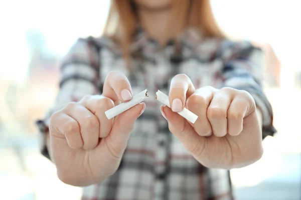 Closeup view of woman breaking cigarette in hands — Stock Photo, Image